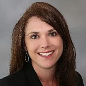 Smiling woman with brown hair in business attire