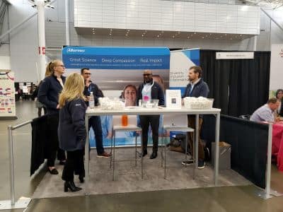 People talking at a company expo booth