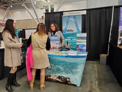 Travel booth with brochures and visitors at expo