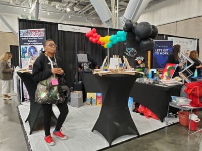 Art expo booth with colorful balloons and displays