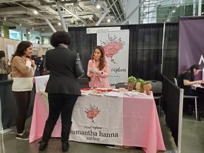 Author speaking with visitors at book fair booth