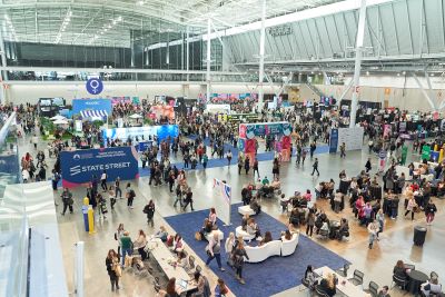 Large convention center filled with people and booths