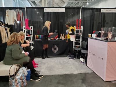 Women shopping at fashion booth with shoes display