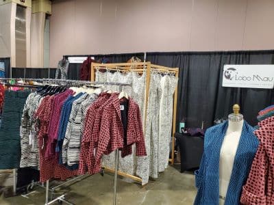 Clothing booth displaying colorful patterned garments at market
