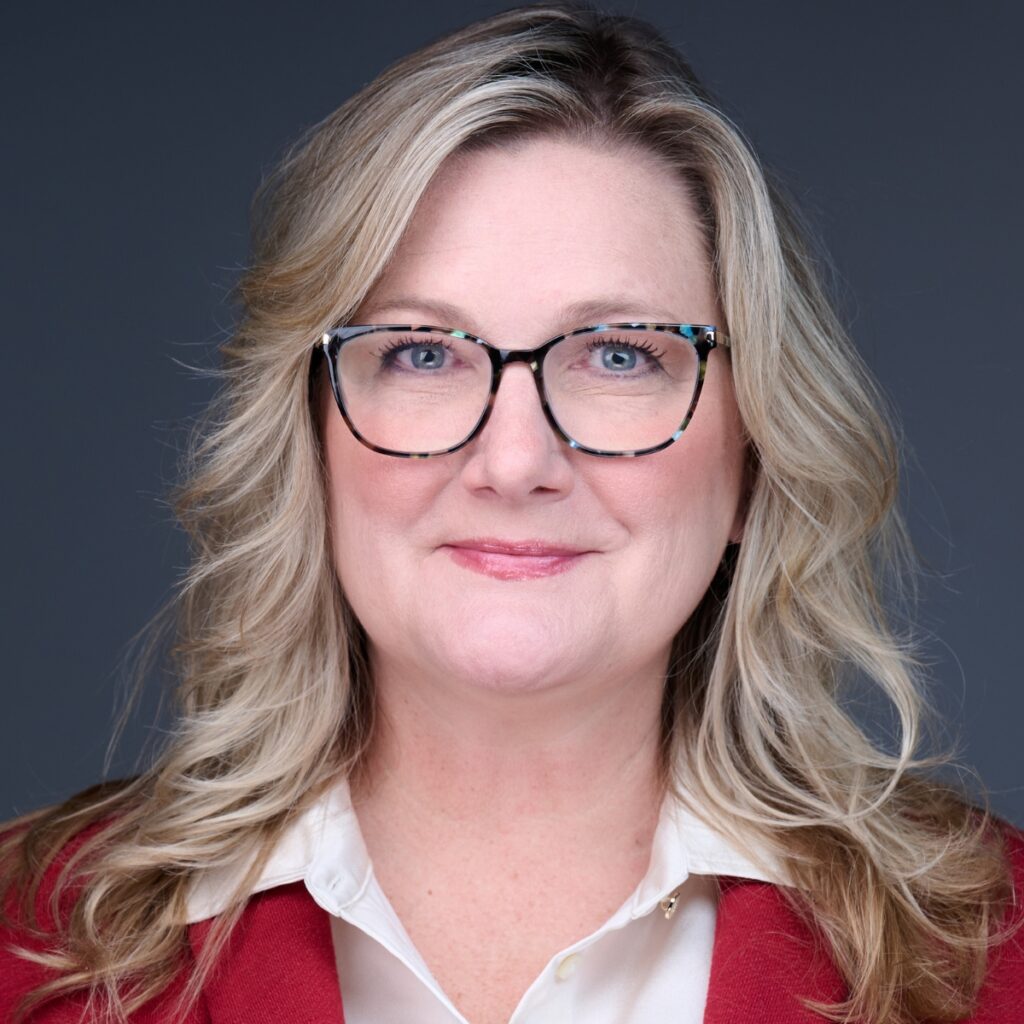 Professional woman wearing glasses and red blazer