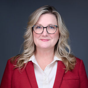 Professional woman wearing glasses and red blazer