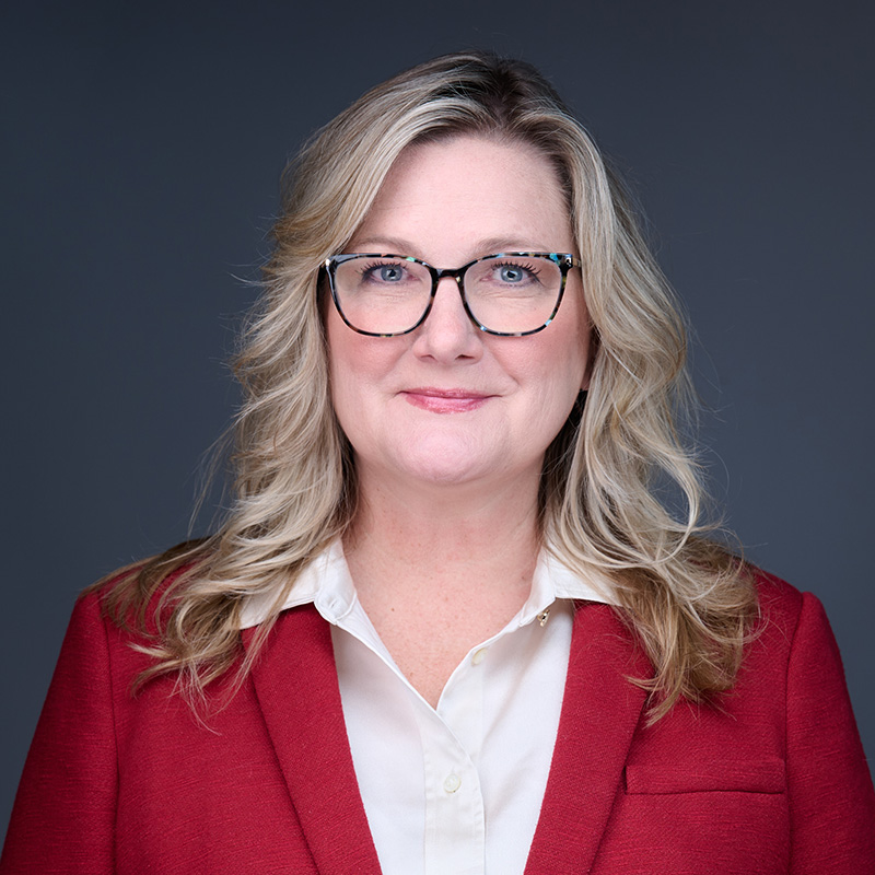 Professional woman wearing glasses and red blazer