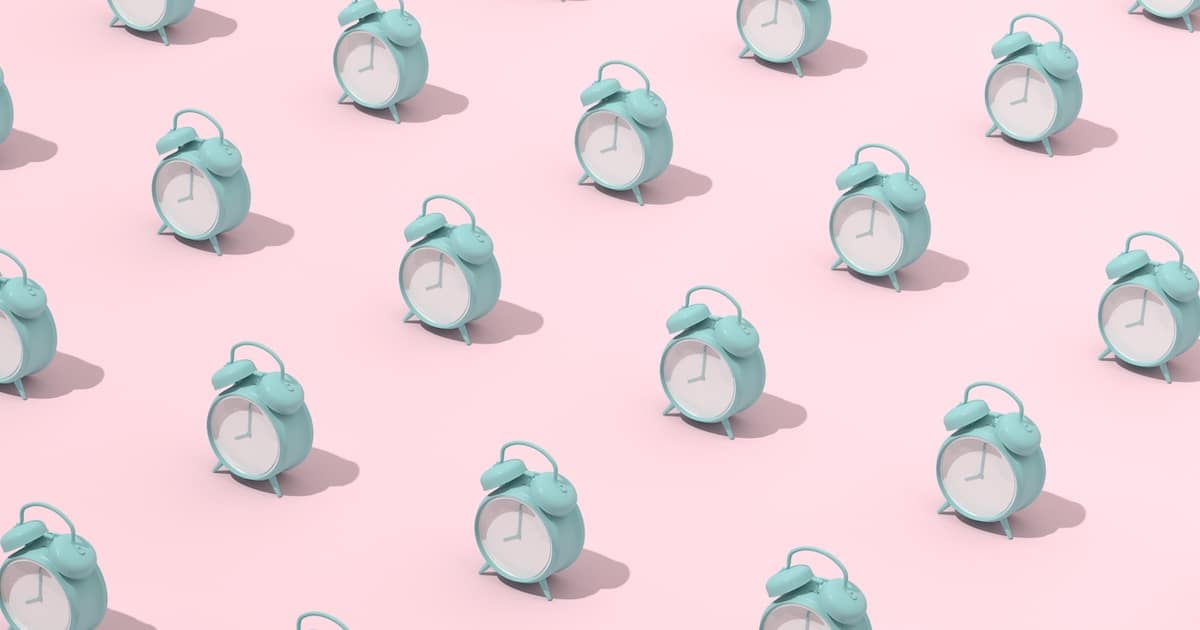 Mint alarm clocks on pink background pattern