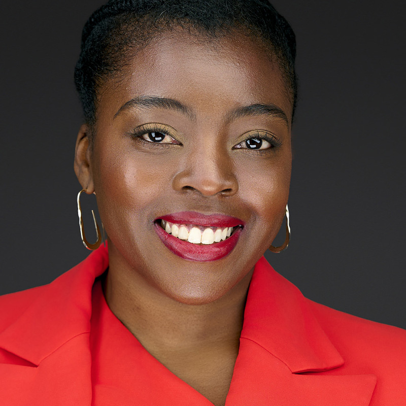 Smiling woman wearing red blazer and gold hoop earrings