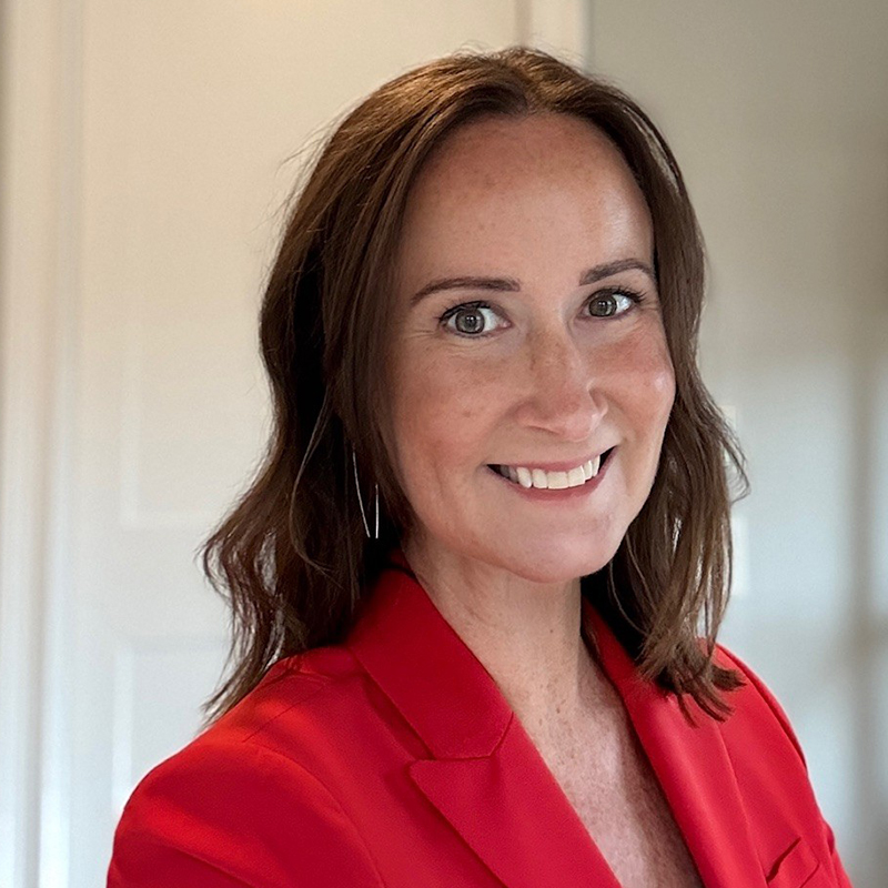 Smiling woman wearing a red blazer indoors