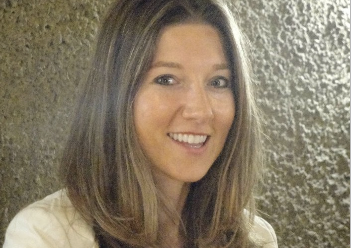 Smiling woman with long brown hair indoors