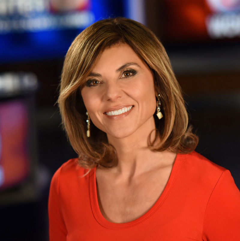 Smiling woman in red top at news studio