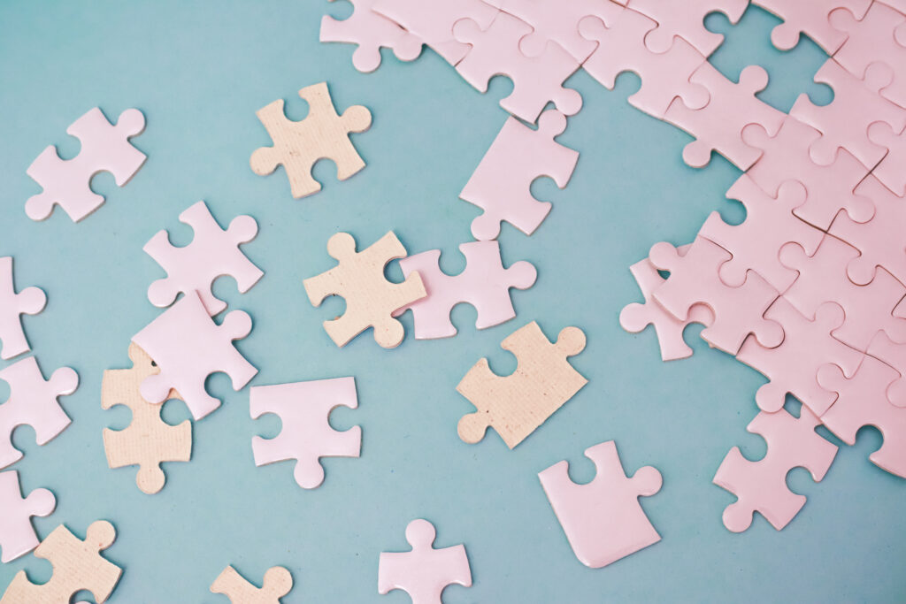 pastel jigsaw puzzle pieces scattered on a light blue surface evoke a sense of playfulness