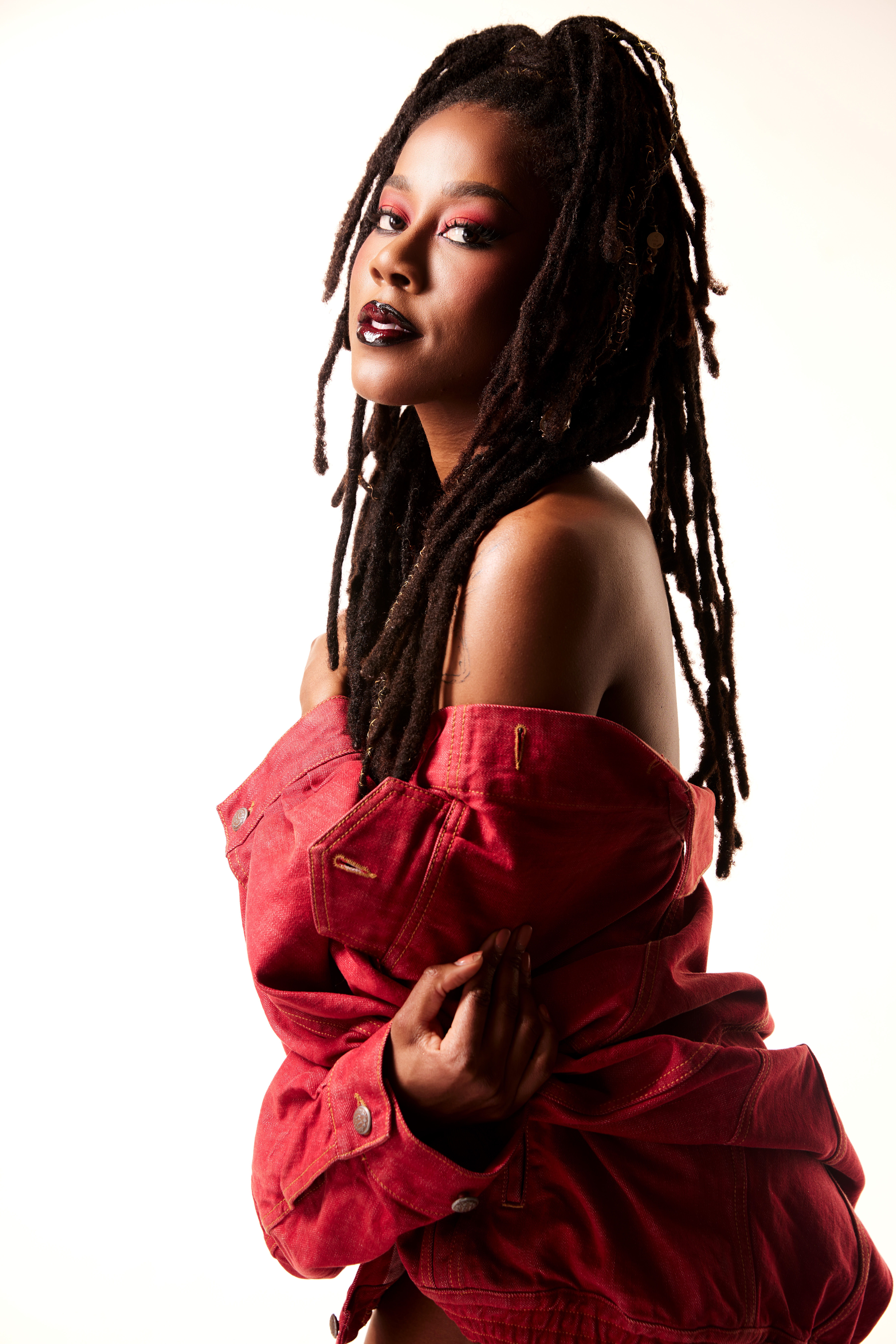 Woman with dreadlocks in red off-shoulder jacket
