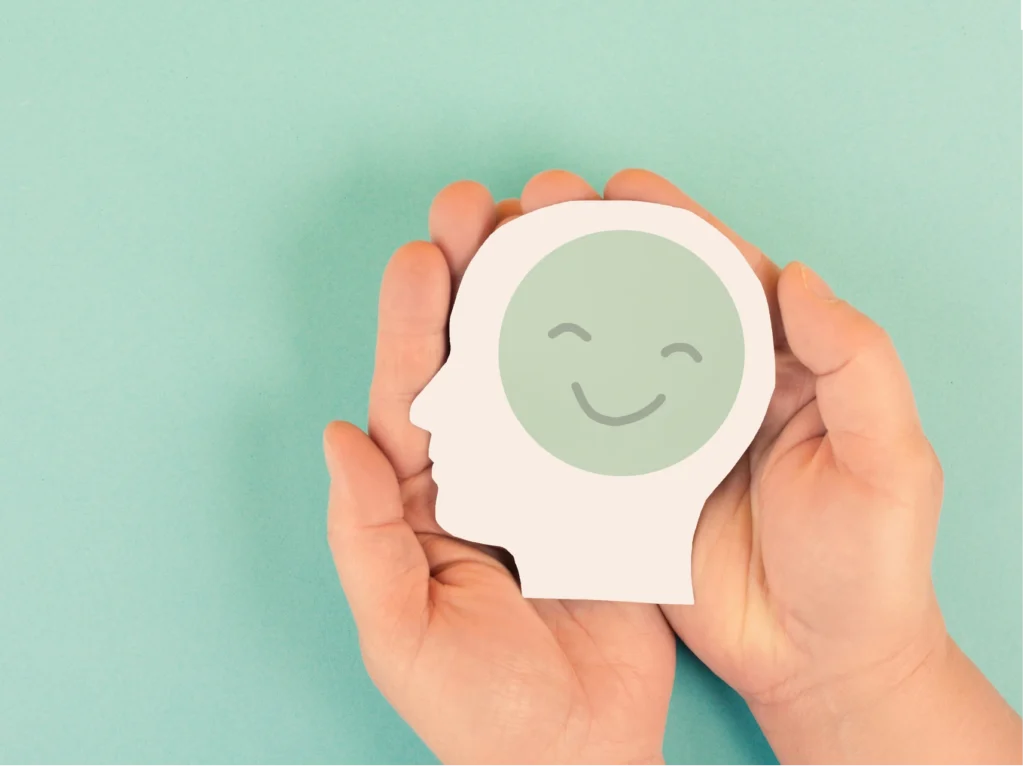 Hands holding smiling face paper head cutout