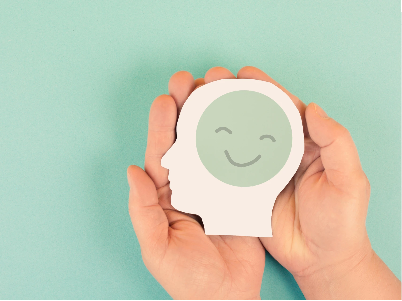 Hands holding smiling face paper head cutout
