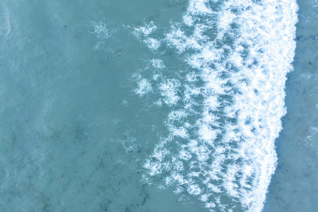 Aerial view of turquoise ocean waves breaking