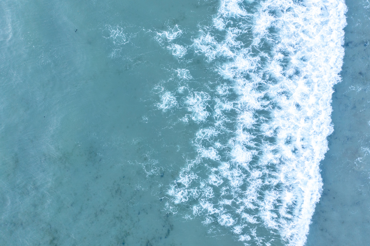 Aerial view of turquoise ocean waves breaking